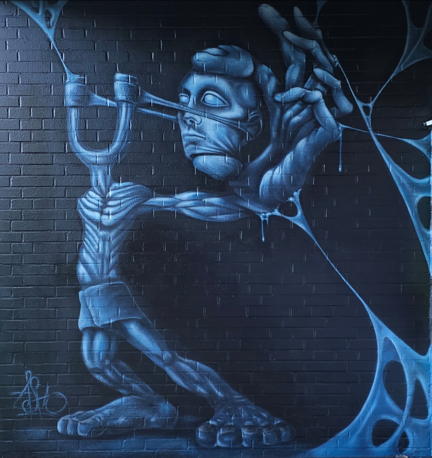 Blaues biomechanisches Wandbild einer Figur mit Schleuder